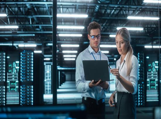 IT people looking at a laptop in a data center